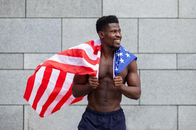 African american man with usa flag smiling on wall background black lives matters