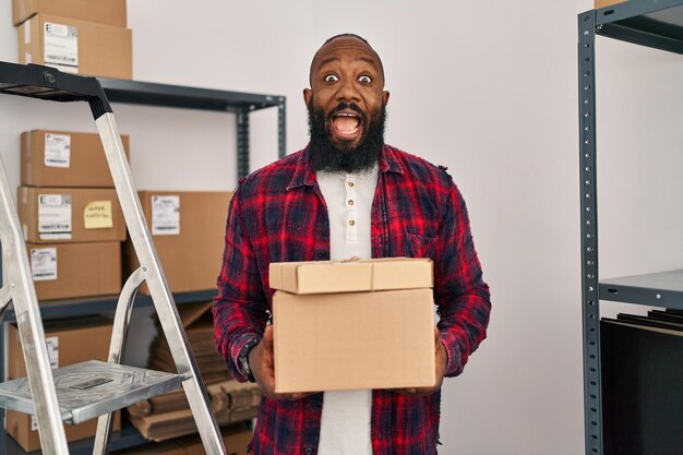 African american man working at small business ecommerce celebrating crazy and amazed for success with open eyes screaming excited.