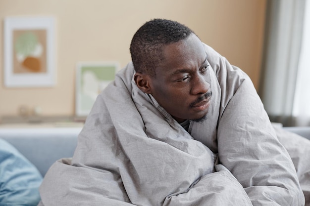 Photo african american man wrapped in blankets struggling with depression