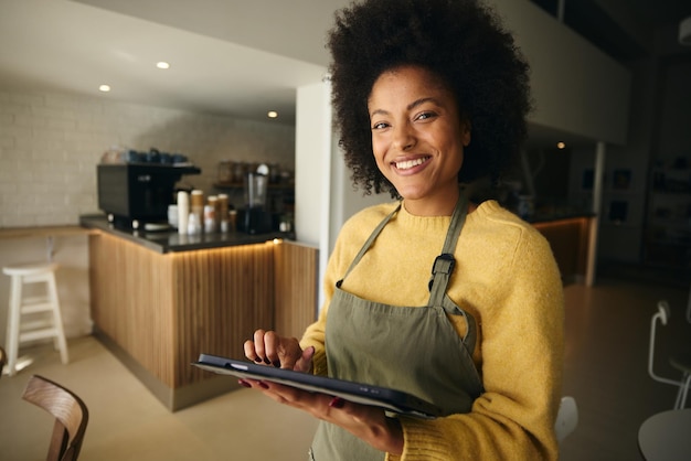 A African American manager smiling while holding a tablet