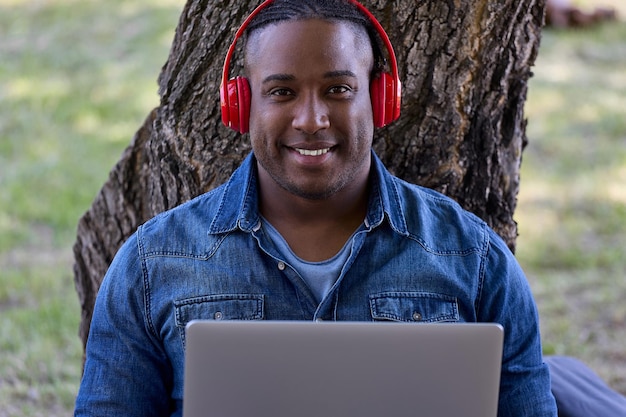 African American meditates to music with headphones in the fresh air