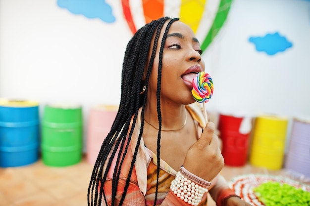 African american millennial lady at candy shop with lolipops