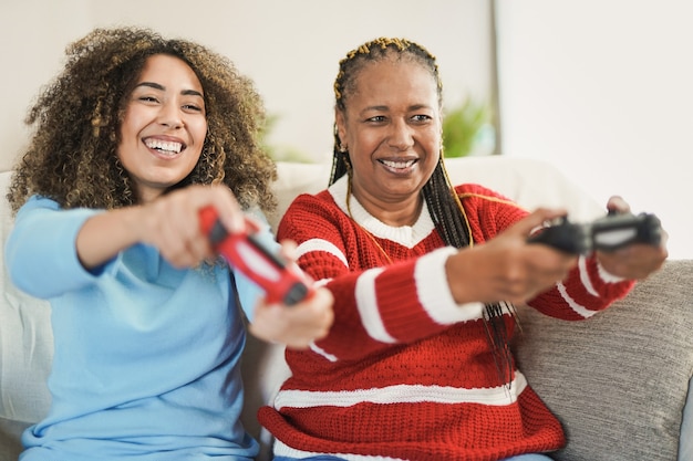 사진 집에서 비디오 게임을 하는 아프리카계 미국인 어머니와 혼혈 성인 딸