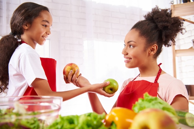 African American mother and daughter in aprons eat