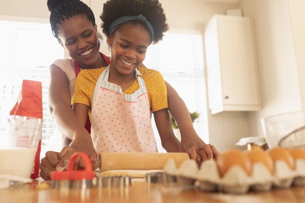 African American mother and daughter baking cookies in kitchen