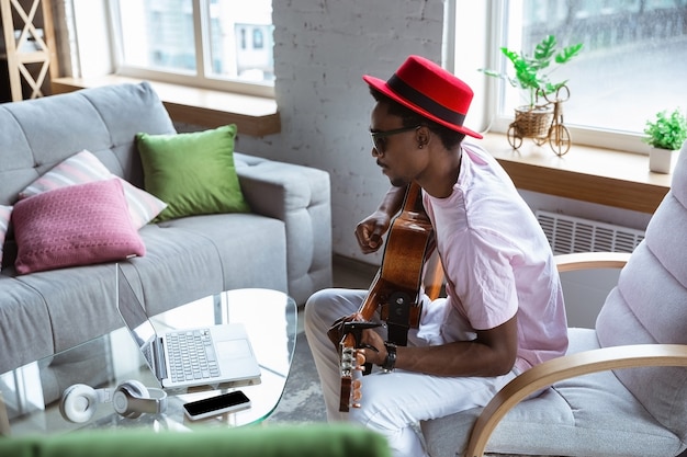 African-american musician greeting audience before online concert at home isolated and quarantined,