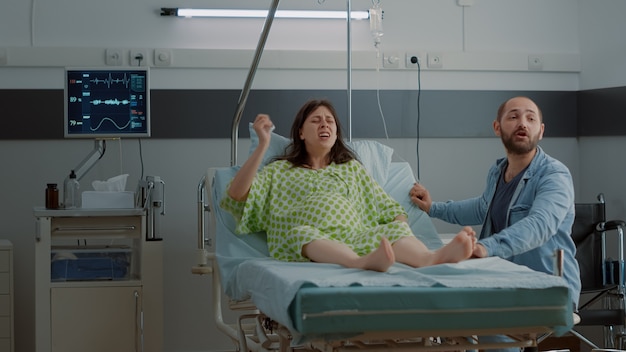 African american nurse assisting pregnant patient with painful labor