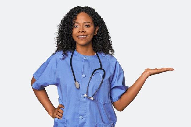 African American nurse in studio background showing a copy space on a palm