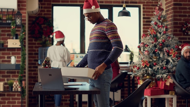 African american person getting fired and losing job during\
winter holiday season, feeling depressed and frustrated about\
unemployment. being unhappy about career failure in festive\
office.