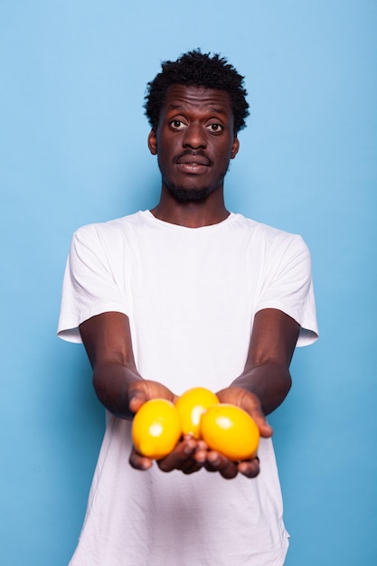 Афро-американский человек держит лимоны и позирует