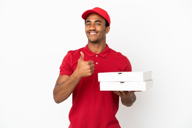 African American pizza delivery man picking up pizza boxes over isolated white wall giving a thumbs up gesture