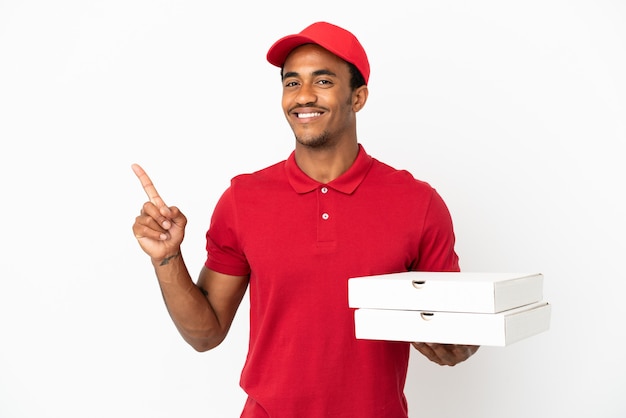 아프리카계 미국인 피자 배달원은 고립된 흰 벽 위에 피자 상자를 들고 최고라는 표시로 손가락을 들어올린다