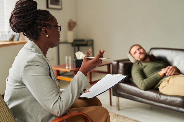 African American psychologist talking to patient at office