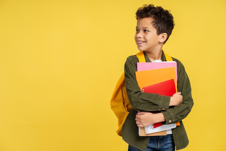 Photo african american pupil with backpack holding books looking to side isolated on yellow background