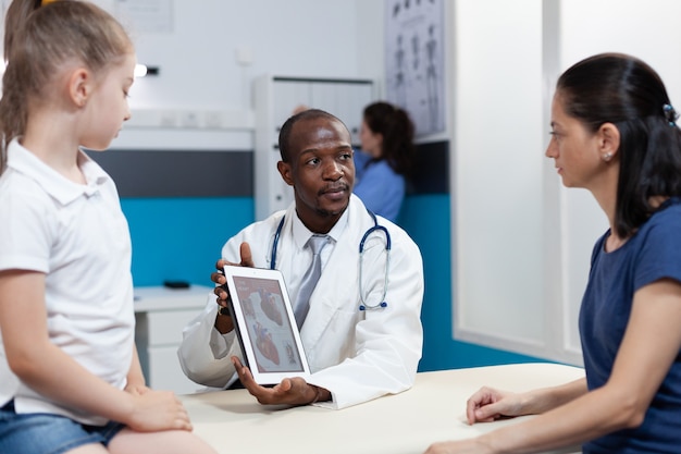 African american radiologist doctor holding tablet computer with heart