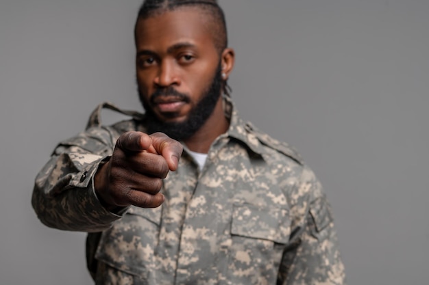 African American serviceman pointing forward with his forefinger