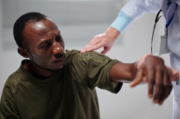 African american soldier with injured arm visiting doctor in military hospital