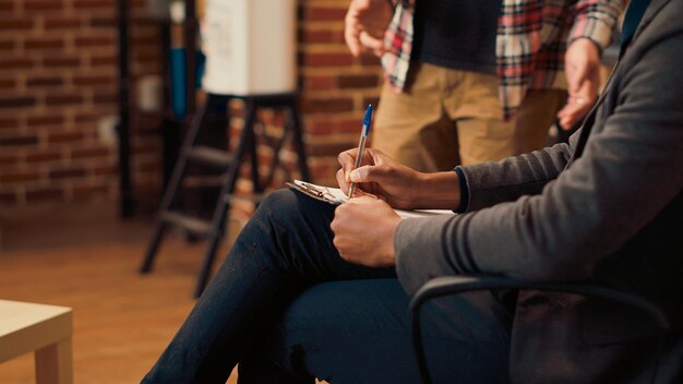 Photo african american specialist taking notes at therapy session with man, listening to marriage conflict and giving professional advice. writing report on papers to give counseling guidance. close up.