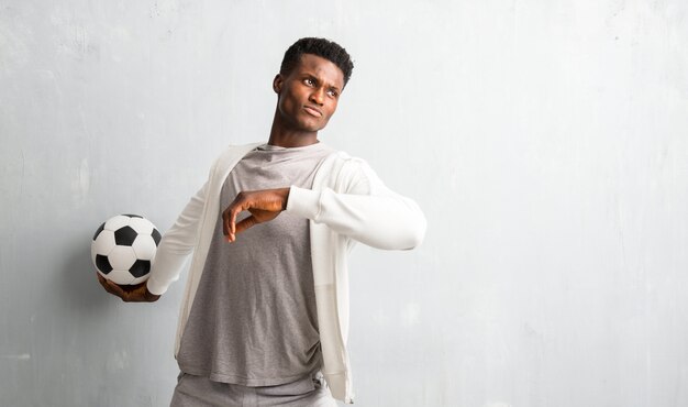 African american sportman holding a soccer ball