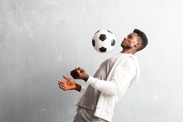 African american sportman holding a soccer ball