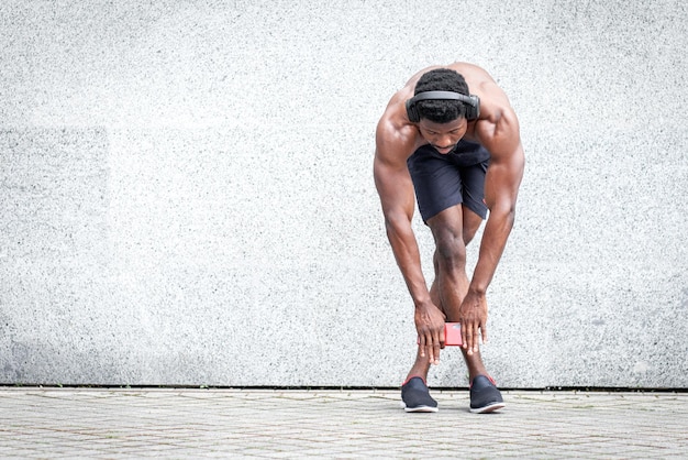 African american sports guy training outdoors against wall