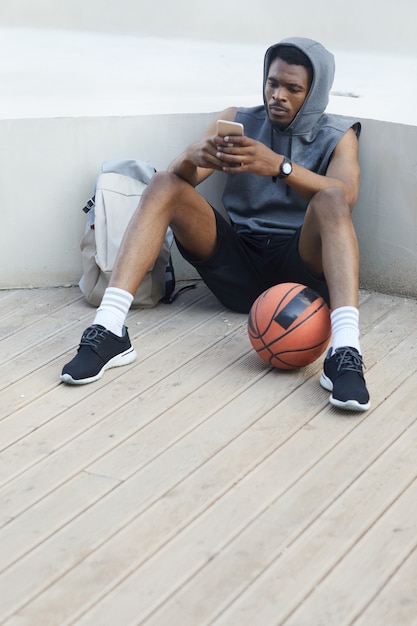 Афро-американский спортсмен с помощью смартфона
