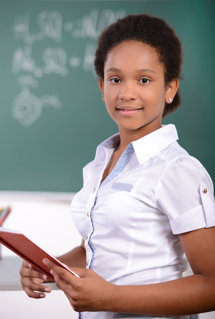 African American student doing math problems on chalkboard.