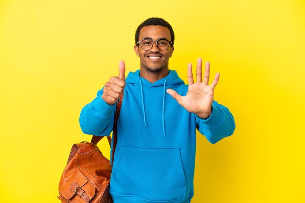 African American student man over isolated yellow background counting six with fingers