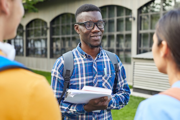 屋外の友達と話しているアフリカ系アメリカ人の学生