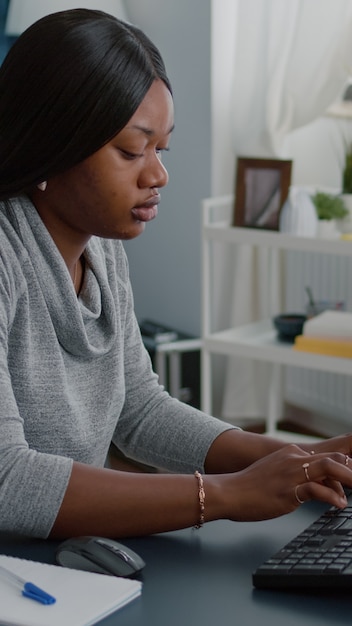 African american student with dark skin working remote from home at marketing online course using we...