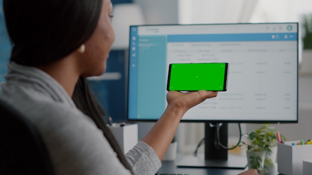 African american student working remote from home looking with mock up green screen