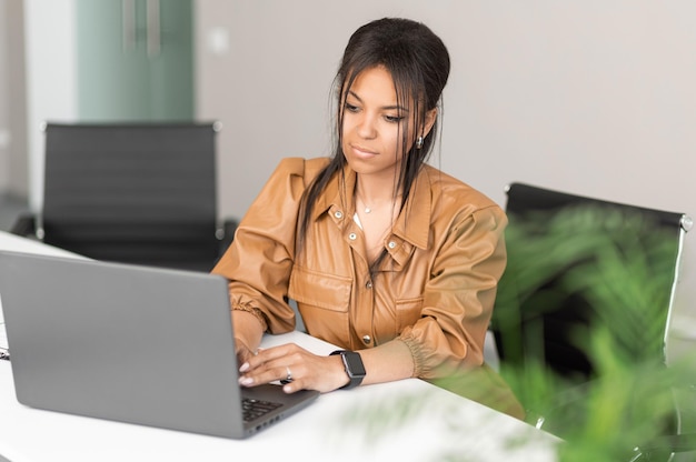 African american successful businesswoman in modern office and working on laptop