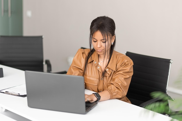 African american successful businesswoman in modern office and working on laptop