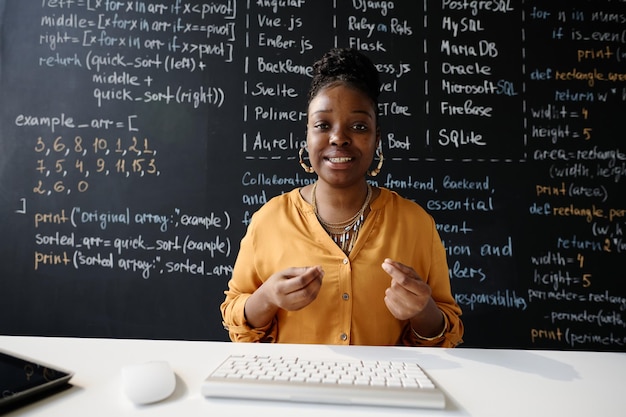 African american teacher smiling at camera while having online lesson on computer at class