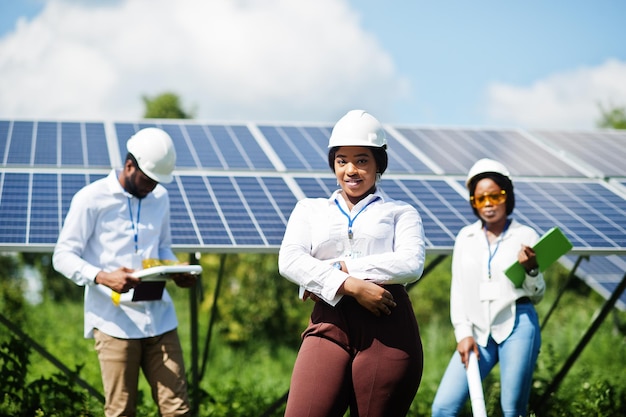 African american technician checks the maintenance of the solar panels Group of three black engineers meeting at solar station