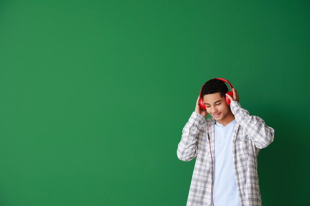 African-American teenage boy listening to music on green