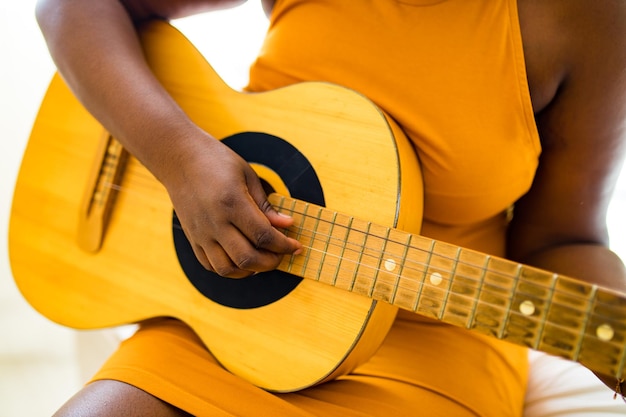 African american teenage girl practicing her skill on acoustic guitar