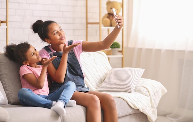 African American teenage girls taking a selfie picture with a smartphone