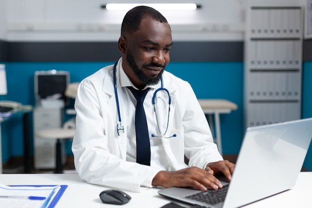 African american therapist doctor typing medical treatment on computer