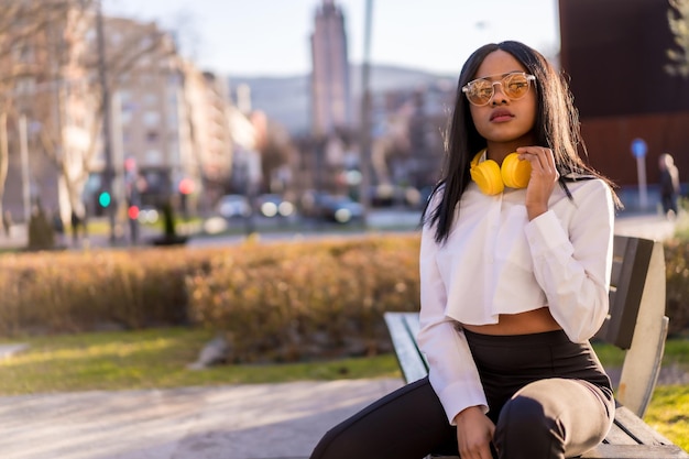 African american vrouw luisteren naar muziek met een koptelefoon in de zomer bij zonsondergang