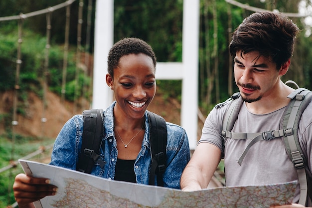 写真 アフリカ系アメリカ人女性と一緒に地図を見ているコーカサス人旅行