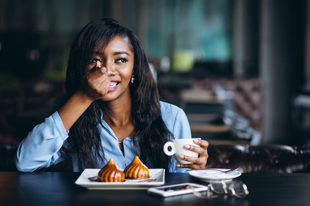 African american woman in a cafe eating dessert