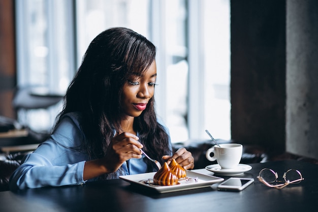 African american woman in a cafe eating dessert