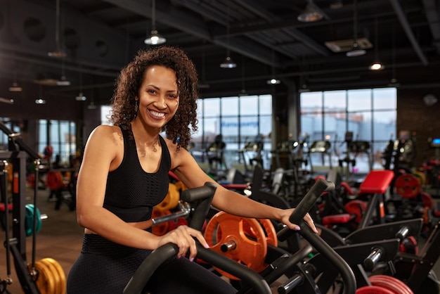 Cardio della donna afroamericana per l'allenamento di aerobica di perdita di peso sullo stile di vita attivo della bici condivide l'allenamento regolare di salute