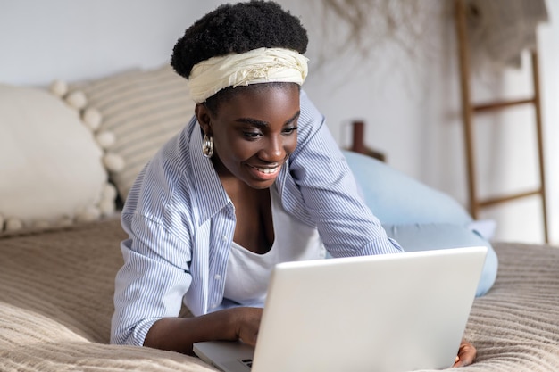 African american woman chatting on internet and looking involved