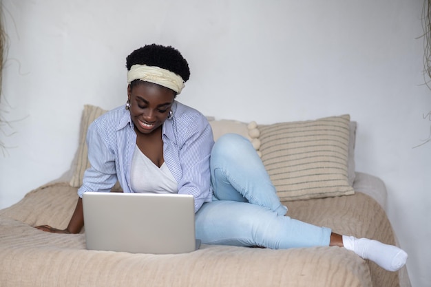 African american woman chatting on internet and looking involved