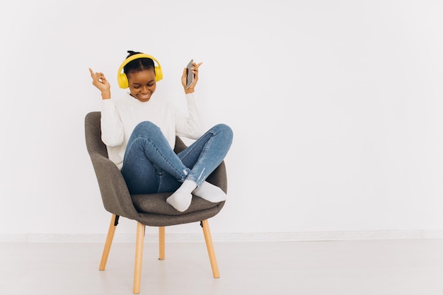 African American Woman Enjoying Music Through Headphones In At Home. Copy Space.