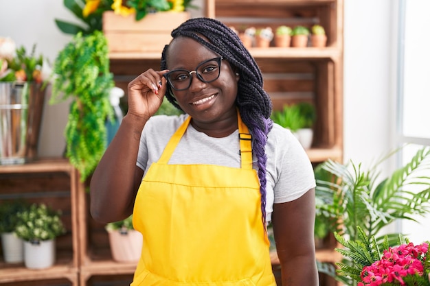 Foto fiorista donna afro-americana sorridente fiducioso in piedi al fiorista