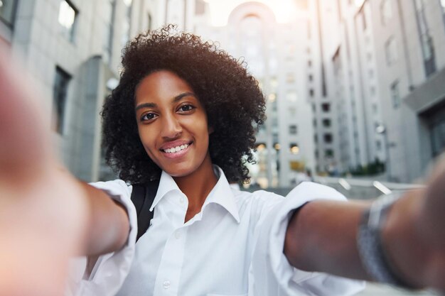 Photo african american woman in good clothes is outdoors in the city at daytime