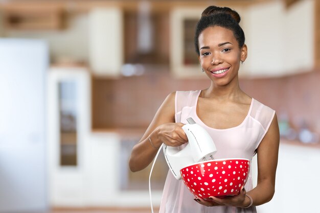 African american woman holding kitchen utensils